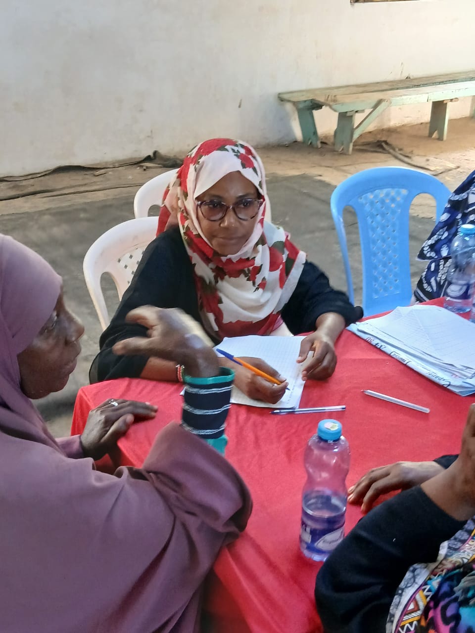 PCF staff reviewing documentation with community members at a table